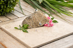 Bird and Butterfly necklace and rings i 925 sterling silver från By K Design, fotograferade med sten och rosa blommor.
