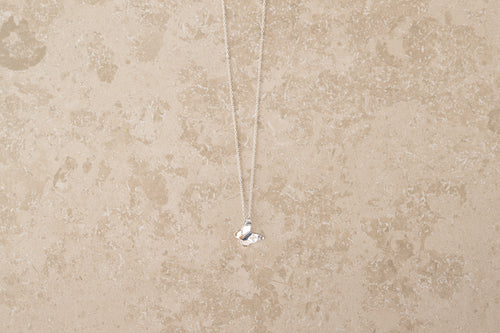 Butterfly necklace i 925 sterling silver från By K Design på beige bakgrund.