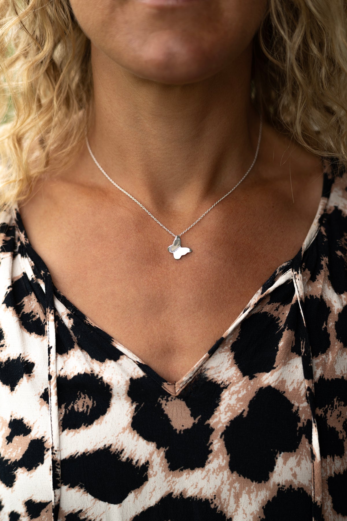 Närbild på butterfly necklace i 925 sterling silver från By K design buren på hals