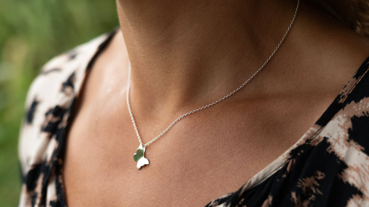 Närbild från sidan på butterfly necklace i 925 sterling silver från By K design buren på hals