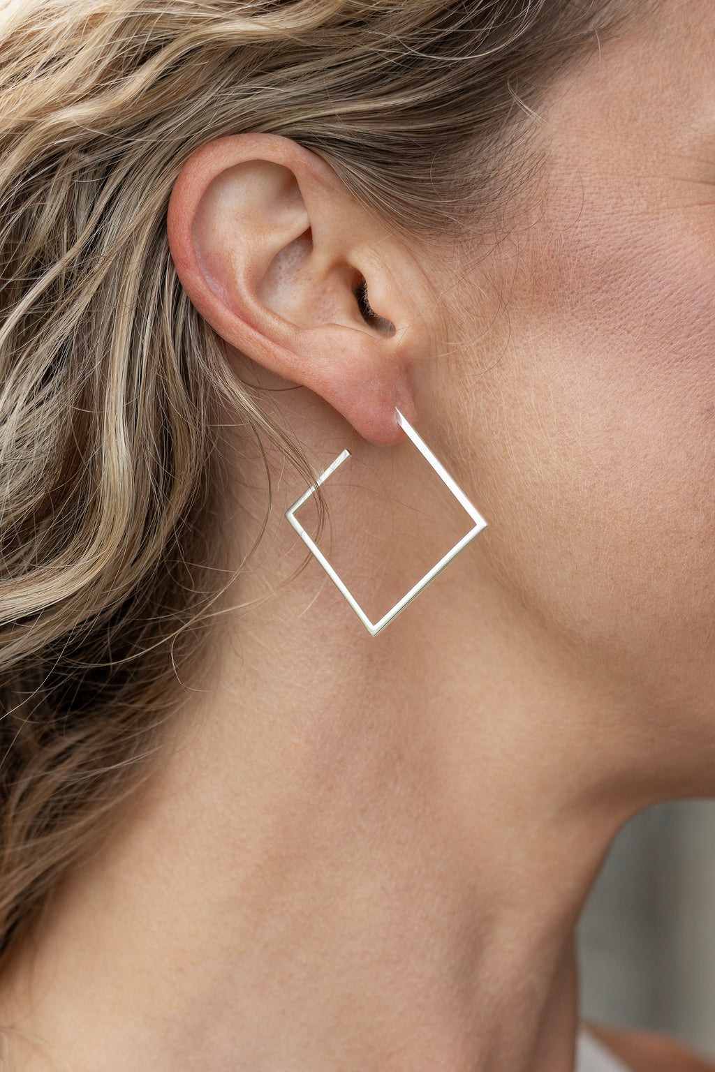 Närbild från sidan på Icon hoops large i 925 sterling silver från By K design buret på örat
